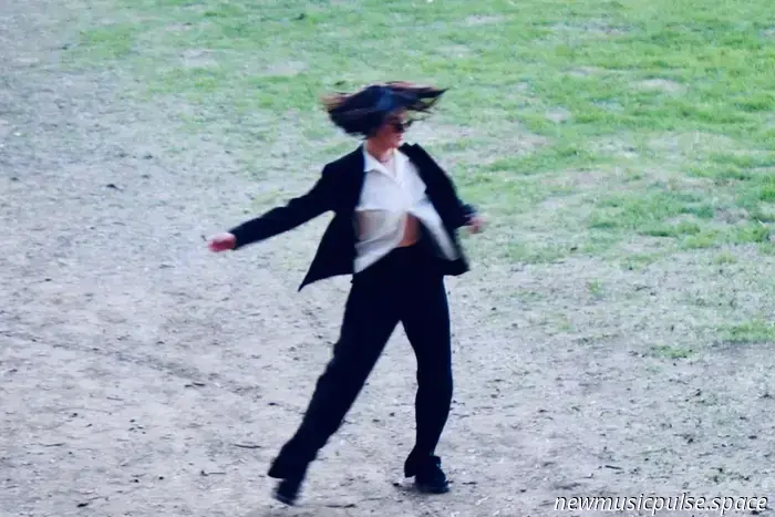 Izzy Outerspace accende una tempesta ardente e carica di emozione in «Closer», il drammatico singolo di lancio del suo prossimo album ‘A Romance Truly Tried’, mescolando confessione cruda con un’eruzione alt-rock cinematografica che arriva dritta all’osso.
Ascolta in streaming: «Closer» – Izzy Outerspace


rami morbidi che tremolano sopra; terra, corteccia, vento e respiro che collassano tutti nello stesso spazio stretto e affamato. Una voce radiante, carica di emozione, squarcia il sottobosco, cavalcando ondate di overdrive sudato e batterie che ribollono e martellano con una forza che sembra vulcanica.
«Closer» di Izzy Outerspace colpisce come un nervo scoperto – un’intima resa dei conti interiore messa su una colonna sonora alternativa cinematografica, appassionata e turbolenta. Le chitarre ruggiscono; le melodie bruciano calde e luminose; le batterie picchiano pesanti, il ritmo afoso e incessante. La voce di Isabelle Baumgartner è incredibilmente viva al microfono, un recipiente di emozione cruda che si sbroglia della propria umanità in tempo reale. È dolorosa; è emotiva; è senza scuse, dinamica e drammatica – oh, quanto è drammatica. «Closer» non è un sussurro di desiderio; è una confessione totale.
Closer – Izzy Outerspace
dimmi
voglio sapere
o riposare nell’ignoto
silenziosi richiami d’aiuto
non sei mai davvero lì
mai soddisfatto
mai soddisfatto
Atwood Magazine è orgogliosa di presentare in anteprima «Closer», il singolo principale e il video musicale estratti dal prossimo disco alternativo di Izzy Outerspace A Romance Truly Tried, in uscita nel 2026. Mixato e masterizzato da Josiah Mazzaschi presso Cave Studio LA e registrato da Christian Paul Philippi, «Closer» segna un nuovo, feroce capitolo per l’artista nata in Svizzera e basata a Los Angeles. Dopo il suo EP Lip Service del 2024 e l’EP Dreamstate del 2025 (prodotto dall’ex membro degli Smashing Pumpkins Jeff Schroeder), questa canzone arriva come il primo assaggio di un disco che spinge più forte, colpisce più a fondo e abbraccia i margini più disordinati dell’amore, del desiderio e del calore emotivo.
«Amo come la scrittura mi aiuti a connettermi con una parte inconscia di me stessa. E come una canzone possa avere significati diversi per ogni ascoltatore. La musica è così potente in questo senso», racconta Baumgartner ad Atwood Magazine. Quel senso di mistero e molteplicità percorre tutto «Closer». Sembra una conversazione con qualcuno che non riesci del tutto a raggiungere – e con la parte di te che ancora, testardamente, lo desidera comunque. «Dimmi / Voglio sapere / o riposare nell’ignoto» oscilla tra confronto e resa, bramando chiarezza pur riconoscendo la sicurezza dell’ambiguità.
mantieni
le tue pupille piccole
sei una
mosca umana
sul muro
penso ancora
a lanciare
quel guinzaglio
volevo solo
tenerti più vicino
Izzy Outerspace «Closer» © 2025

Man mano che la canzone si approfondisce, la sua tensione si stringe ulteriormente. I testi di Baumgartner oscillano tra inquietante e intimo – «mantieni le tue pupille piccole / sei una mosca umana sul muro» – dipingendo il suo soggetto come una presenza sfuggente e scattante, sempre vicina ma mai pienamente presente. La ripetuta confessione, «volevo solo tenerti più vicino, più vicino», trasforma il ritornello in un mantra di desiderio, rassegnazione e bisogno emotivo crudo. La sua voce cavalca la distorsione con un calore che sembra quasi pericoloso, incrinandosi ai bordi giusto il necessario per lasciare che il dolore filtri. È turbolenta e carica di emozione, una febbre alt-rock che non si placa mai del tutto.
Il video che accompagna la canzone, girato e montato da Molly Koch, mantiene tutto radicato e immediato. Girato all’aperto tra alberi e fitta vegetazione, non sovraspiega né impone un concetto: offre invece uno sguardo non filtrato e ravvicinato su Izzy Outerspace e i suoi compagni di band – Tommy Oerding alla batteria e Clifton Weaver al basso – incastrati nella tempesta della canzone. La natura diventa una cornice morbida per il caos, uno sfondo vivente mentre si scatenano, sudano e bruciano attraverso la resa dei conti interiore di Baumgartner.
se sei ancora qui
se sei ancora qui
ti offro
ti offro
il mondo
Quella performance è il nucleo emotivo di «Closer». Baumgartner canta come se stesse cercando di artigliare la verità – o di allontanarsene – con ogni respiro sforzato e ogni crescendo infuocato. La produzione sposa quella volatilità, lasciando che le chitarre ringhino, il basso macini e le batterie perforino il mix senza levigare i bordi più ruvidi della canzone. È drammatico nel miglior modo possibile: grandi sentimenti, grandi suoni e un senso di immediatezza che rende il tutto vivo nelle tue mani.
Izzy Outerspace «Closer» © 2025

Izzy Outerspace «Closer» © 2025
Nata e cresciuta in Svizzera e ora residente a Los Angeles, Baumgartner è cresciuta immersa nel Britpop, nel punk tedesco e nel forte richiamo emotivo dell’avere imparato la chitarra tardi nella vita. «L’ho sempre visto come un processo meditativo», dice. «Mi piace e voglio creare musica in cui senti di entrare in un regno diverso e puoi in qualche modo scomparire.» Negli ultimi anni – dal suo debutto del 2020 Amazon a Caught del 2022, Lip Service del 2024 e Dreamstate del 2025 – si è ritagliata un’identità sonora costruita su introspezione, atmosfera, distorsione e liberazione emotiva.
non voglio fingere
voglio solo essere
la tua amica
non voglio fingere
volevo solo tenerti più vicino
A Romance Truly Tried sembra la culminazione di quell’evoluzione, un corpo di lavoro che apre le sue costole anziché nascondersi dietro la foschia. «Closer», in uscita il 21 novembre, è il suo primo, bruciante capitolo: un’eruzione drammatica, appassionata e carica di emozione che perdura a lungo dopo che l’accordo finale si dissolve. Lascia che questa canzone ti attragga nella sua orbita, ti tenga nel suo calore e veda cosa emerge in superficie quando ti avvicini un po’ di più. Ascolta questo singolo e guarda il video musicale in esclusiva su Atwood Magazine, e lascia che ti sieda addosso l’intensità di tutto ciò che Izzy Outerspace mette a nudo in questa resa dei conti carica e vorticosa.
— —
:: ascolta/acquista Closer qui ::
:: connettiti con Izzy Outerspace qui ::
— —
Ascolta in streaming: «Closer» – Izzy Outerspace

— — — —
Collegati con Izzy Outerspace su
Facebook, TikTok, Instagram
Scopri nuova musica su Atwood Magazine
 © per gentile concessione dell’artista
:: Ascolta Izzy Outerspace ::